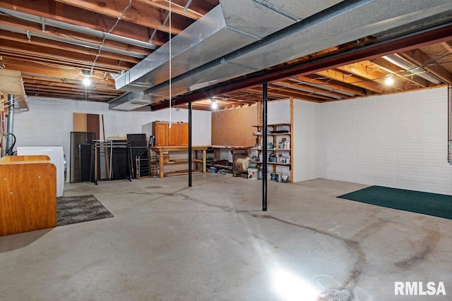 unfinished below grade area with washer / dryer and brick wall