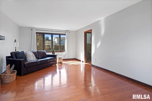 living area with baseboards and wood finished floors