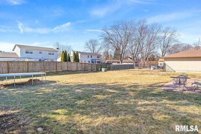 view of yard with a trampoline and a fenced backyard