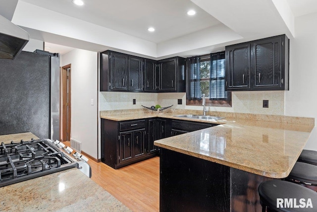 kitchen with freestanding refrigerator, dark cabinetry, and a sink