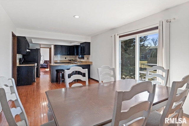 dining room with light wood-style flooring and recessed lighting