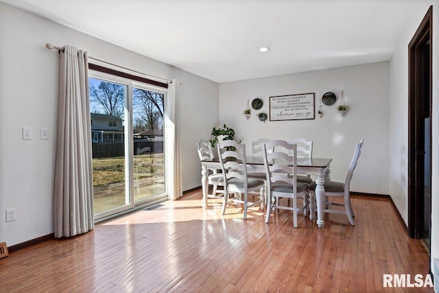 dining area with visible vents, light wood-style flooring, and baseboards