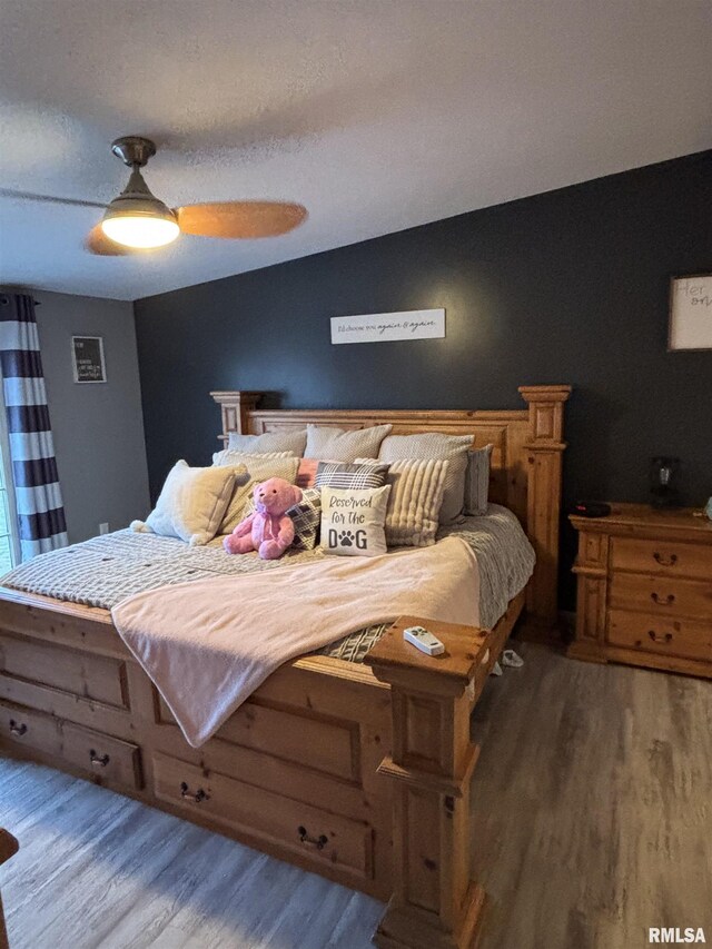 bedroom with lofted ceiling, ceiling fan, and wood finished floors