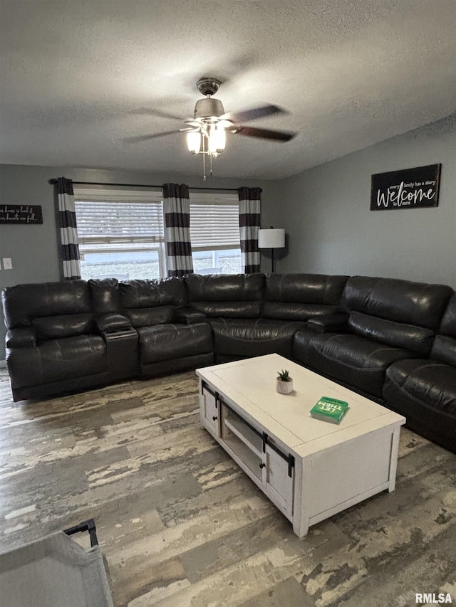 living room featuring ceiling fan, a textured ceiling, visible vents, and wood finished floors