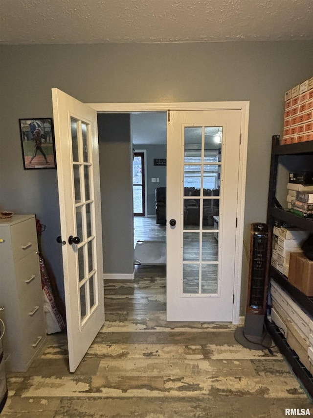 doorway to outside featuring a textured ceiling, french doors, and wood finished floors