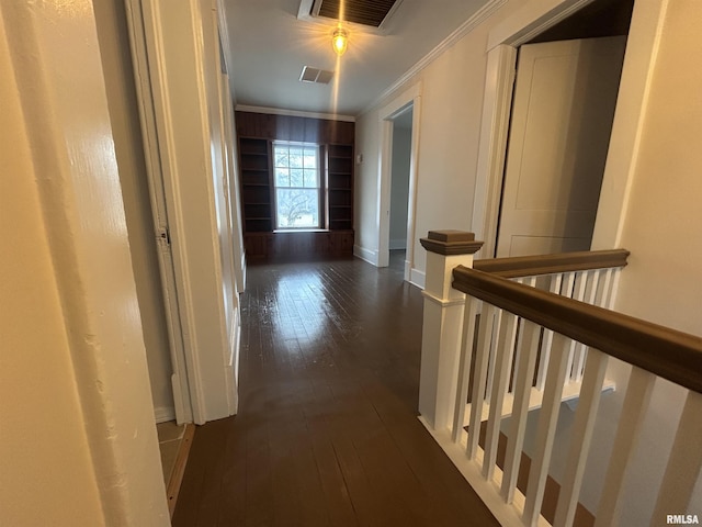 hall with dark wood-style floors, visible vents, crown molding, and an upstairs landing