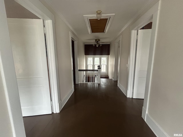 hall with ornamental molding, baseboards, an upstairs landing, and dark wood-style floors