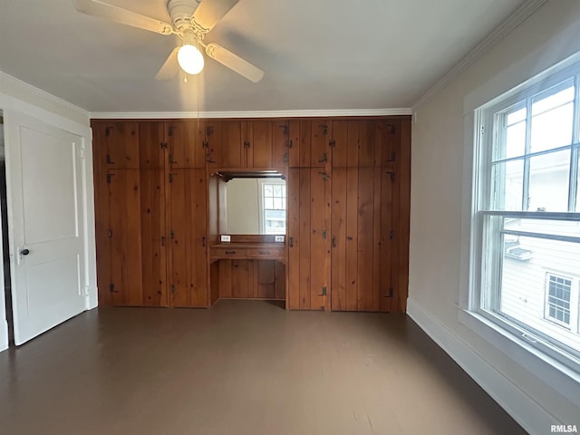 unfurnished bedroom featuring finished concrete flooring, baseboards, ceiling fan, crown molding, and a closet