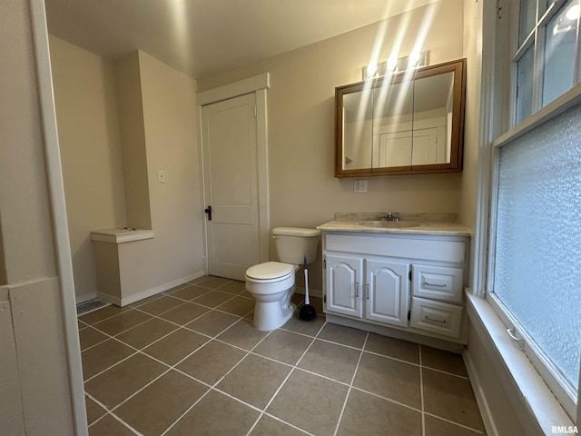 half bathroom featuring vanity, tile patterned flooring, toilet, and baseboards