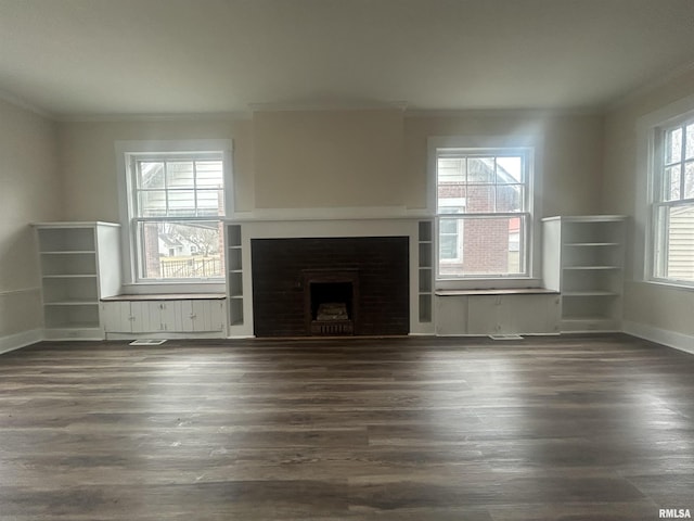 unfurnished living room featuring a fireplace, visible vents, baseboards, ornamental molding, and dark wood finished floors