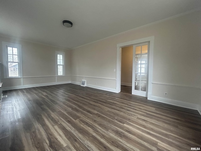 unfurnished room featuring dark wood-style floors, ornamental molding, and visible vents