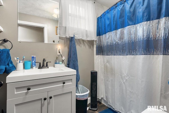 bathroom featuring a shower with curtain, wood finished floors, a textured ceiling, and vanity