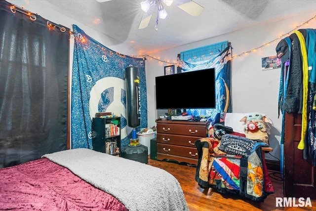 bedroom featuring a textured ceiling, a ceiling fan, and wood finished floors