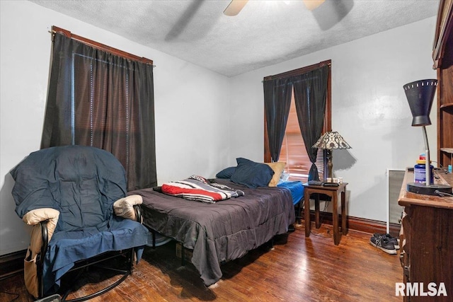 bedroom featuring a textured ceiling, a ceiling fan, and wood finished floors