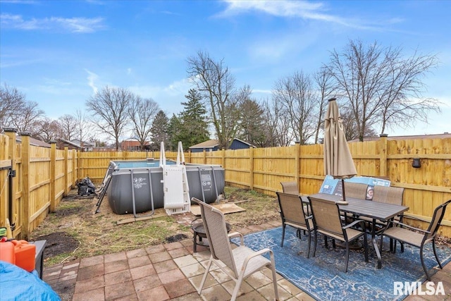 view of patio / terrace featuring a fenced backyard, a fenced in pool, and outdoor dining space