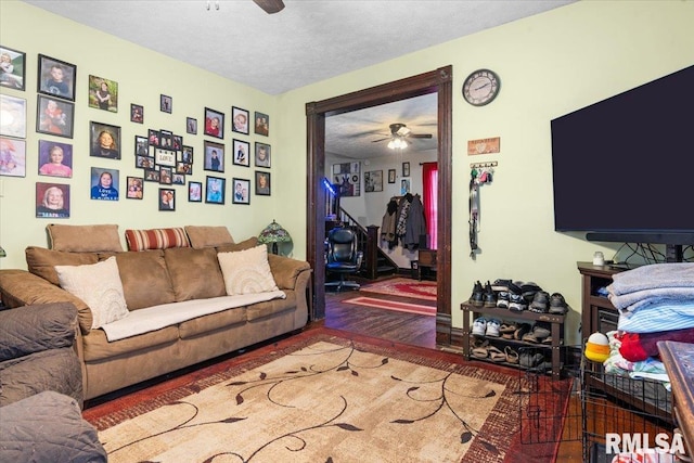 living room featuring ceiling fan, a textured ceiling, and wood finished floors