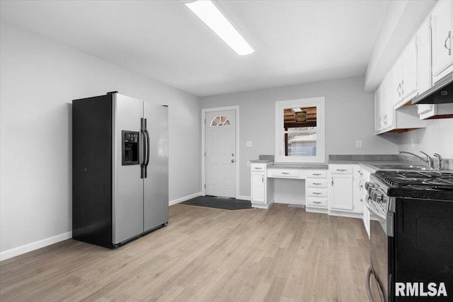 kitchen with appliances with stainless steel finishes, light wood-type flooring, white cabinets, and built in study area