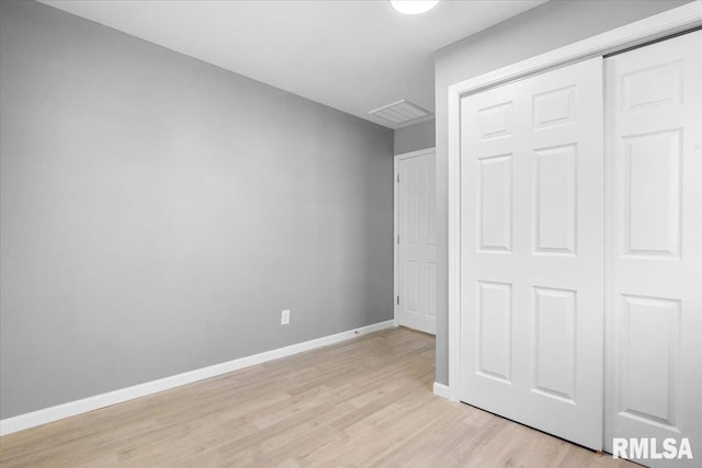 unfurnished bedroom with light wood-style flooring, visible vents, baseboards, and a closet