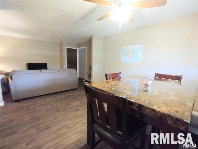 dining area featuring a textured ceiling, a ceiling fan, and wood finished floors