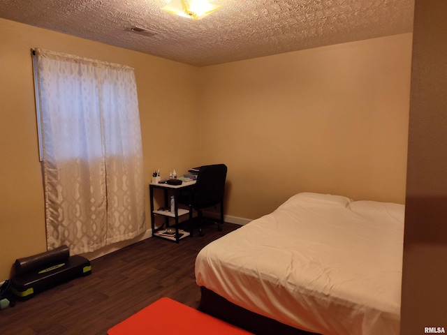 bedroom with dark wood-style flooring, a textured ceiling, and baseboards