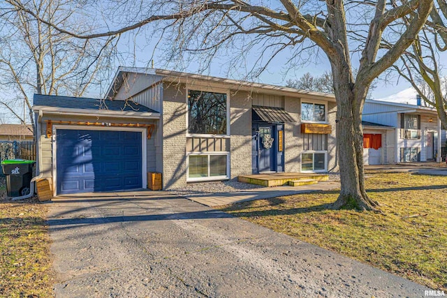 view of front of home with a garage, driveway, brick siding, and cooling unit