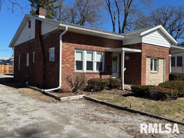 view of front of property with brick siding and a chimney