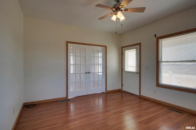 unfurnished room with visible vents, baseboards, and wood finished floors