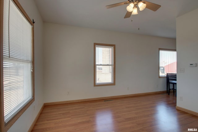 unfurnished room featuring visible vents, ceiling fan, light wood-style flooring, and baseboards