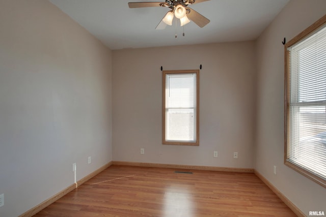 empty room featuring baseboards, ceiling fan, and light wood-style floors