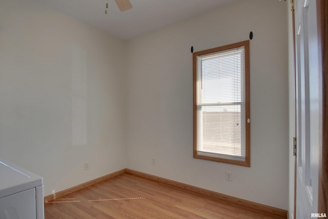 empty room with light wood-style floors, washer / clothes dryer, baseboards, and a ceiling fan