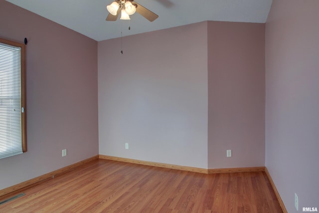 unfurnished room featuring a ceiling fan, light wood-style flooring, visible vents, and baseboards