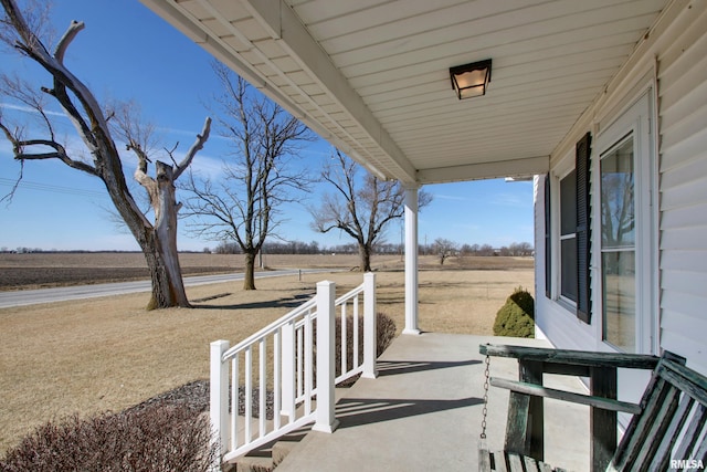 view of patio / terrace featuring a porch and a rural view