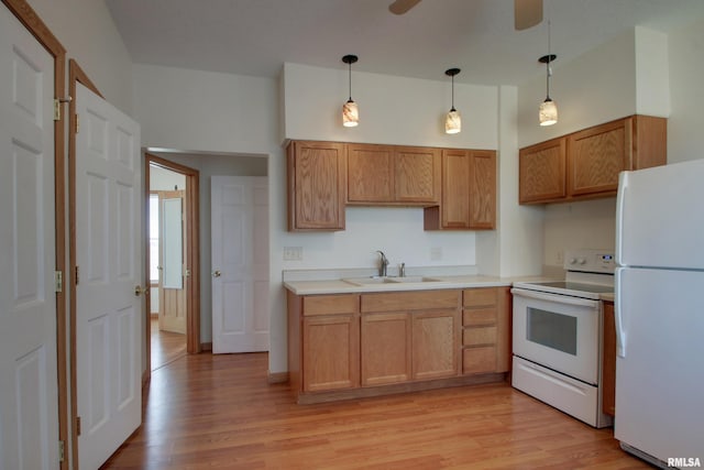 kitchen featuring light wood-style floors, white appliances, light countertops, and a sink