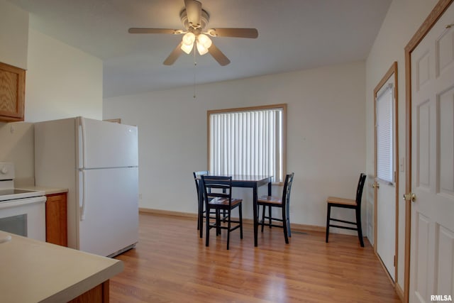 kitchen featuring light countertops, white appliances, brown cabinetry, and light wood-style floors