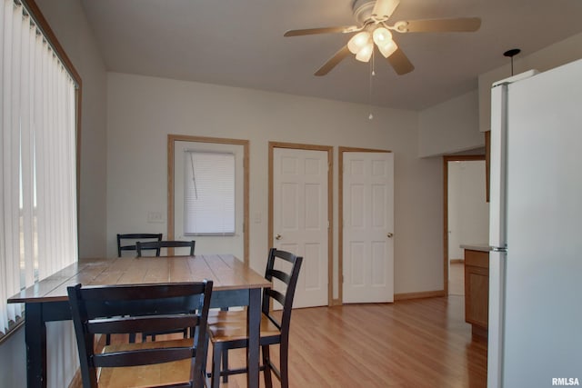 dining room with light wood-type flooring, ceiling fan, and baseboards