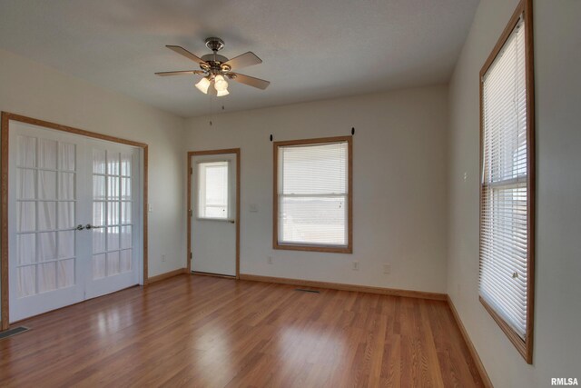 unfurnished room with a ceiling fan, baseboards, visible vents, and light wood finished floors