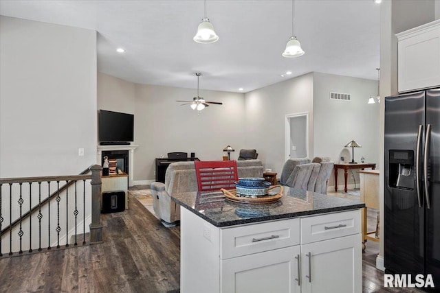 kitchen featuring visible vents, a tiled fireplace, open floor plan, stainless steel fridge with ice dispenser, and dark wood-style flooring