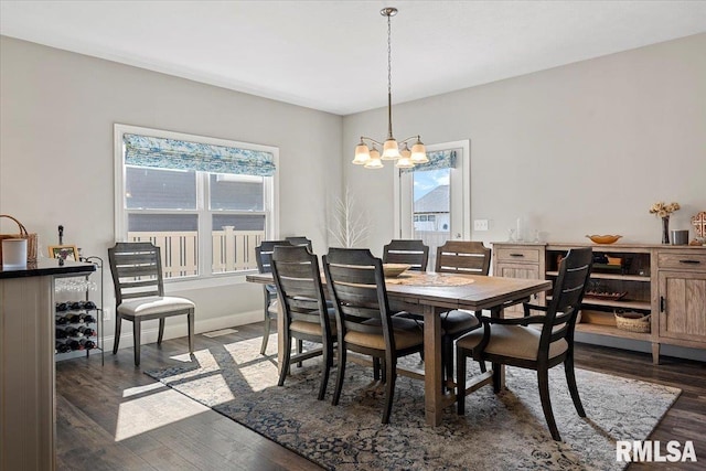 dining space with dark wood-style floors, an inviting chandelier, and baseboards