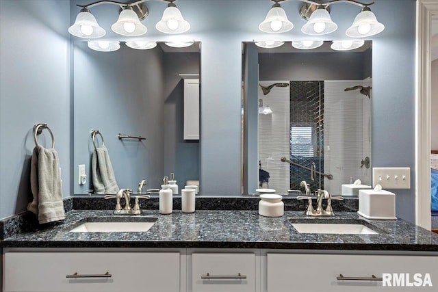 bathroom featuring double vanity, a stall shower, and a sink