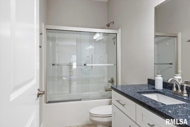 bathroom featuring combined bath / shower with glass door, toilet, and vanity