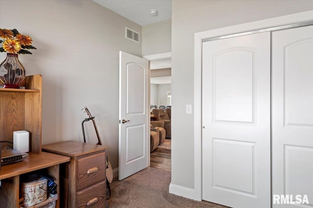 carpeted office space with baseboards and visible vents