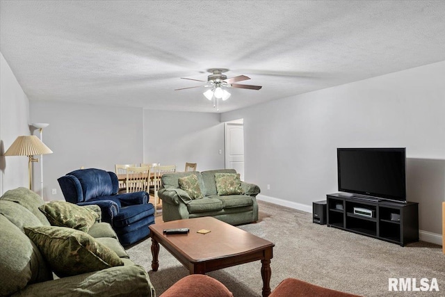 living area with baseboards, a textured ceiling, and carpet flooring