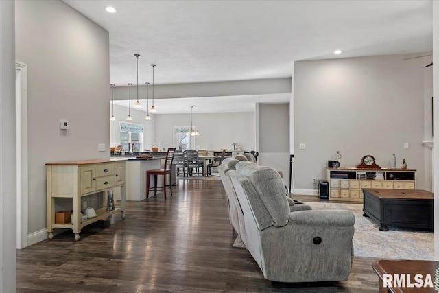 living area featuring recessed lighting, baseboards, and dark wood-style flooring