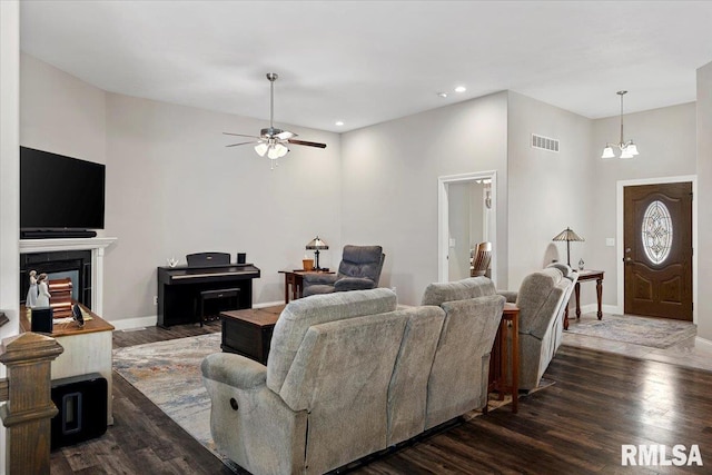 living room with visible vents, baseboards, and dark wood-style floors