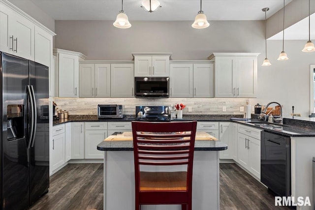 kitchen featuring white cabinetry, black appliances, tasteful backsplash, and a sink