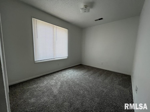 empty room with baseboards, carpet, visible vents, and a textured ceiling