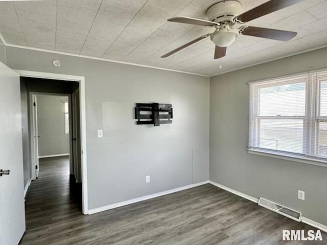 unfurnished room with baseboards, crown molding, visible vents, and wood finished floors