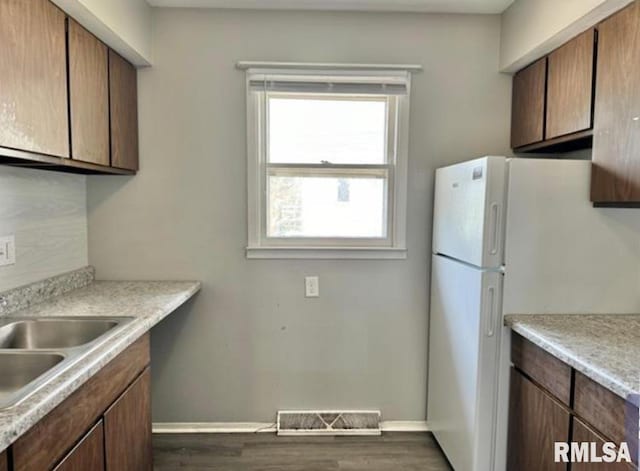 kitchen with freestanding refrigerator, dark wood-style flooring, visible vents, and baseboards