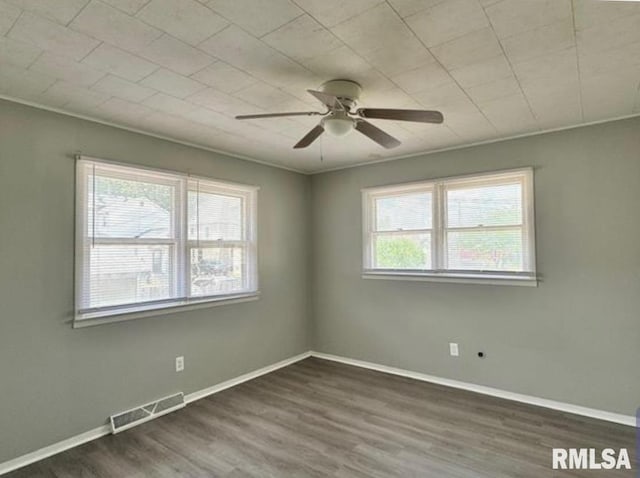 unfurnished room with baseboards, crown molding, visible vents, and wood finished floors