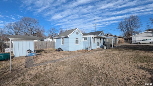 view of side of property featuring a storage shed, a lawn, an outdoor structure, and fence